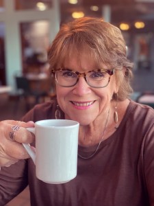Photo of Joy Daunis holding a white cup
